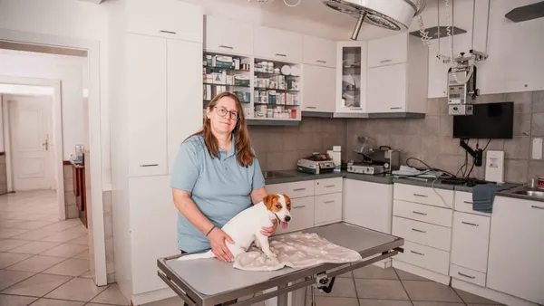 Tierärztin mit einem kleinen Hund auf dem Untersuchungstisch